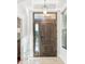 Elegant wooden front door with sidelight and transom window, tile flooring at 583 Treehouse St, Winter Springs, FL 32708