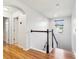Upstairs hallway featuring hardwood floors, white railings, and natural light from a window at 583 Treehouse St, Winter Springs, FL 32708