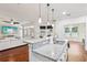 Kitchen island with granite countertops and pendant lighting, open to a living area with a ceiling fan at 583 Treehouse St, Winter Springs, FL 32708