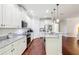 Bright kitchen featuring white cabinets, granite countertops, stainless steel appliances, and hardwood floors at 583 Treehouse St, Winter Springs, FL 32708