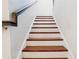 Stairway with wooden treads and white risers leading to the upper level of the house at 583 Treehouse St, Winter Springs, FL 32708