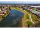 Scenic aerial view of property near a lush golf course and serene lake at 8011 Saint James Way, Mount Dora, FL 32757