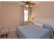 Cozy bedroom with a ceiling fan, window with blinds, and a comfortable bed with a white headboard at 8011 Saint James Way, Mount Dora, FL 32757