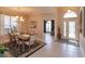 Open-concept dining room with decorative chandelier, modern furniture and view to the home's foyer at 8011 Saint James Way, Mount Dora, FL 32757