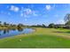 Scenic golf course view featuring a tranquil pond and lush green fairways under a bright blue sky at 8011 Saint James Way, Mount Dora, FL 32757