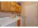 Functional laundry room with wooden cabinets, a folding counter, washer, and dryer for efficient chores at 8011 Saint James Way, Mount Dora, FL 32757