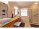 Elegant main bathroom with dual vanities, a soaking tub, and a glass-enclosed shower at 8011 Saint James Way, Mount Dora, FL 32757
