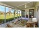 Relaxing screened patio with comfortable seating, a ceiling fan, and serene views of the surrounding landscape at 8011 Saint James Way, Mount Dora, FL 32757