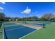 Multiple outdoor tennis courts with blue and green surfaces, offering ample space for recreational activities at 8011 Saint James Way, Mount Dora, FL 32757