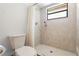 Bathroom features a toilet, tile shower, and a small window for natural light at 813 Mellowood Ave, Orlando, FL 32825