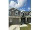 Two-story townhome featuring a two-car garage and neutral-tone horizontal siding at 9436 Westside Hills Dr, Davenport, FL 33896