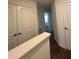 Upstairs hallway with neutral colored carpet and white doors at 9436 Westside Hills Dr, Davenport, FL 33896