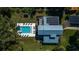Aerial view of a modern home featuring a sparkling pool, outdoor lounge area, and a metal roof with solar panels at 9575 Ne 306Th Ct, Fort Mc Coy, FL 32134
