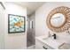 Stylish bathroom with a modern vanity, decorative mirror, and a walk-in shower at 9575 Ne 306Th Ct, Fort Mc Coy, FL 32134