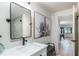 Modern bathroom with white vanity, black fixtures, shower and view to game room at 9575 Ne 306Th Ct, Fort Mc Coy, FL 32134