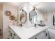Bright bathroom featuring dual vanities with black hardware and sconces, shiplap walls and decorative accents at 9575 Ne 306Th Ct, Fort Mc Coy, FL 32134