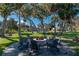 Relaxing backyard stone fire pit with Adirondack chairs surrounded by mature trees at 9575 Ne 306Th Ct, Fort Mc Coy, FL 32134