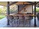 Charming outdoor kitchen offers bar seating, grill, and sink, perfect for entertaining guests at 9575 Ne 306Th Ct, Fort Mc Coy, FL 32134