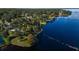 Aerial view of a lush waterfront property featuring a pool, mature trees, and direct access to the serene water at 9575 Ne 306Th Ct, Fort Mc Coy, FL 32134