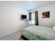 Bedroom featuring a seafoam-colored bedspread and a wall-mounted TV at 993 Calico Pointe Cir, Groveland, FL 34736