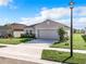 Charming one-story home featuring a well-manicured lawn, inviting front entrance, and attached two-car garage at 993 Calico Pointe Cir, Groveland, FL 34736