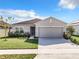 Charming single-story home features a well-maintained lawn, tidy landscaping, and a two-car garage at 993 Calico Pointe Cir, Groveland, FL 34736
