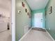 Inviting hallway with light green walls, tiled floor, and a laundry room for convenient chores at 993 Calico Pointe Cir, Groveland, FL 34736