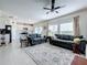 Bright living room with a ceiling fan, large windows and an open floor plan to the kitchen at 993 Calico Pointe Cir, Groveland, FL 34736