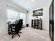 Bright room with an office setup featuring a desk, shelving, and a comfortable chair at 993 Calico Pointe Cir, Groveland, FL 34736