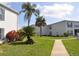 View of condo buildings, green space, sidewalk, and tropical plants at 1006 Plantation Dr # F11, Kissimmee, FL 34741