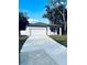 Single story home with a crisp white exterior, two-car garage, and a long concrete driveway for easy parking at 1015 25Th St, Orlando, FL 32805