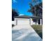 Charming single-story home featuring a clean white exterior, attached two-car garage, and well-lit driveway at 1015 25Th St, Orlando, FL 32805