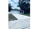 New single-story home with a white exterior, an attached garage, and a long concrete driveway at 1015 25Th St, Orlando, FL 32805