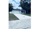 Single-story home featuring a concrete driveway, white exterior and an attached garage at 1015 25Th St, Orlando, FL 32805