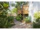 Backyard view of a patio and the house's wooden deck, surrounded by tropical plants and stone path at 12 S Lawsona Blvd, Orlando, FL 32801