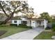 Single-story home with mature landscaping, a long driveway, and a covered carport at 12 S Lawsona Blvd, Orlando, FL 32801