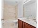 Bright bathroom featuring a cherry vanity with marble countertop and tile shower at 1218 Falling Star Ln, Orlando, FL 32828