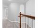 Second floor hallway featuring neutral carpet, stairs with wooden banister, and great natural light at 1218 Falling Star Ln, Orlando, FL 32828