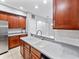 Modern kitchen featuring wooden cabinetry, stainless steel appliances, granite countertops, and a double basin sink at 1218 Falling Star Ln, Orlando, FL 32828