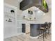 Finished basement bar area with a granite countertop, seating, and built-in shelving with decorative elements at 13231 Woodford St, Orlando, FL 32832