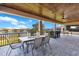 Covered patio with wood ceiling, stone floor, metal chairs, and a lake view at 13231 Woodford St, Orlando, FL 32832