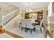 Bright dining area with hardwood floors, elegant furnishings, and a staircase adds to the room's character at 14216 Mailer Blvd, Orlando, FL 32828