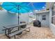 Outdoor screened patio area features paving stones, a large picnic table, and umbrella at 14216 Mailer Blvd, Orlando, FL 32828