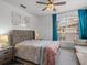 This cozy bedroom has a ceiling fan, large window, and calming wall decor at 1431 Milledge Ln, Davenport, FL 33896