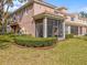 Charming home exterior featuring a screened patio and lush landscaping at 1431 Milledge Ln, Davenport, FL 33896