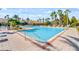 Resort-style community pool with palm trees, lounge chairs, and a clear blue sky at 1431 Milledge Ln, Davenport, FL 33896