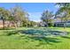 View of the community putting green surrounded by mature trees and well-maintained landscaping on a sunny day at 1431 Milledge Ln, Davenport, FL 33896