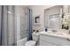 Bright bathroom with a tub and shower, white vanity, stylish mirror, and decorative accents at 1442 Ironbark Bnd, Davenport, FL 33837