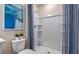 Shower stall with built-in shelving and blue-themed painting hanging above the toilet at 1442 Ironbark Bnd, Davenport, FL 33837