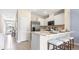 Well-lit kitchen featuring white cabinets, stainless steel appliances, and a breakfast bar at 1442 Ironbark Bnd, Davenport, FL 33837